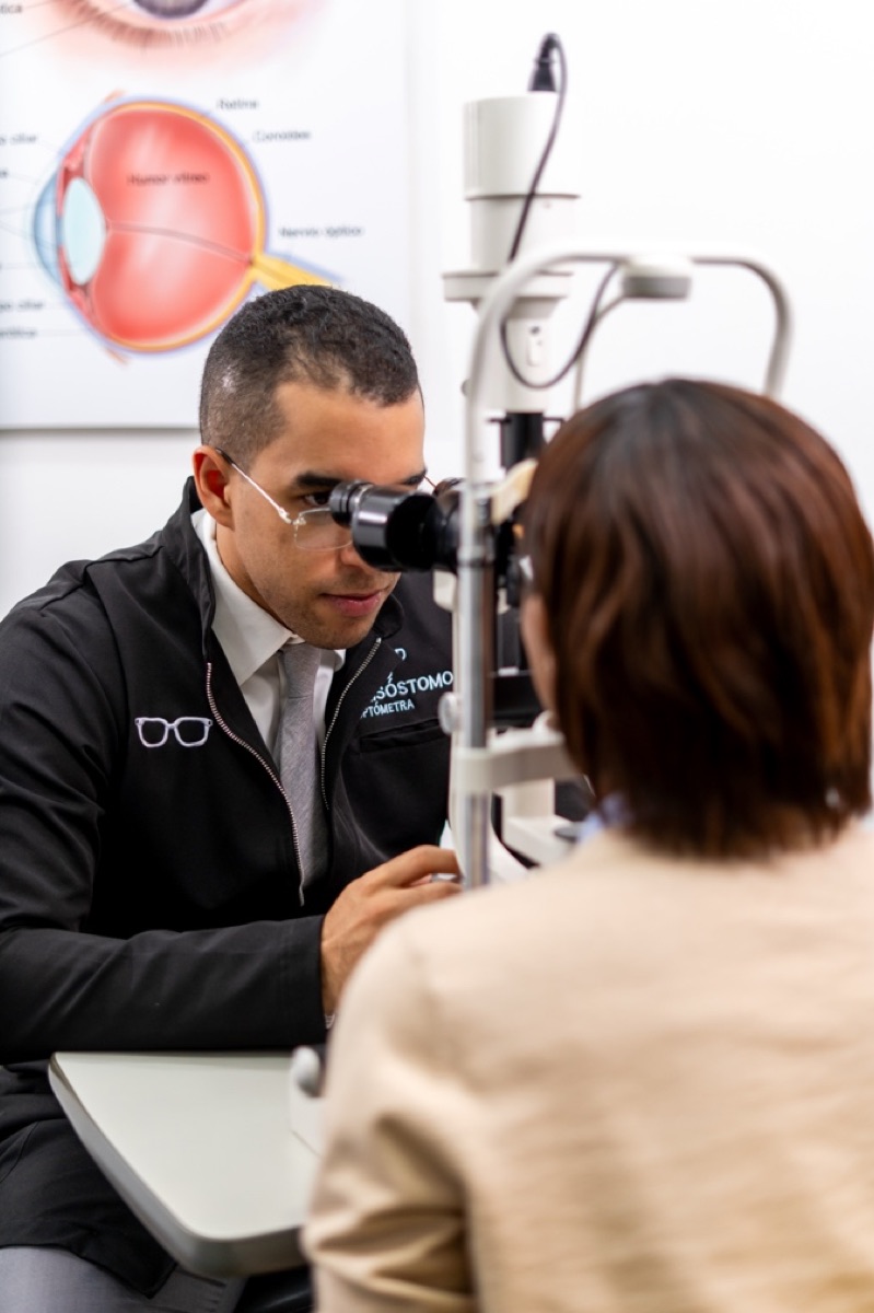 El optometrista Arnold Brito Crisóstomo examina a una paciente en BC Optical